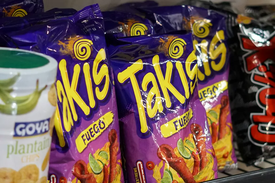 Bags of Takis Fuego on a shop shelf beside other imported snacks