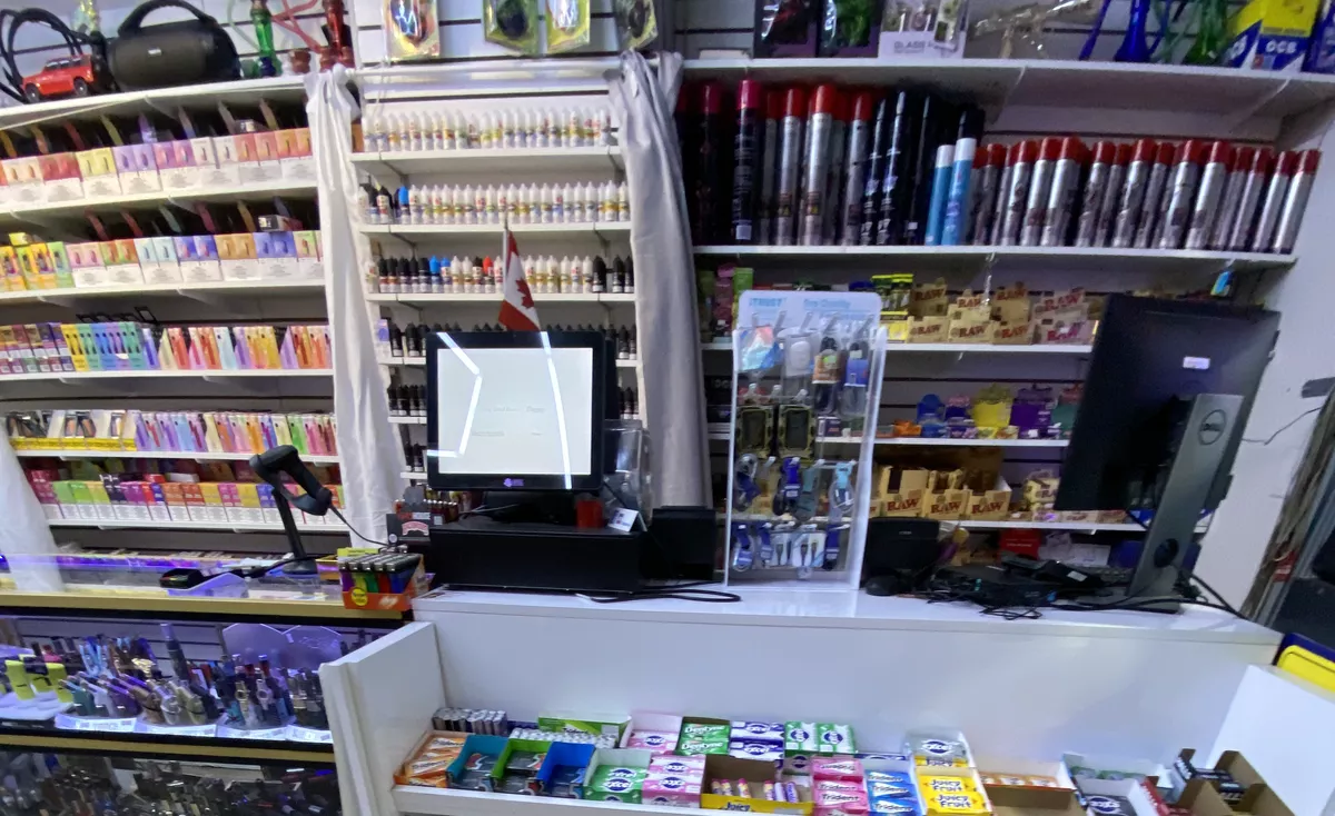 The vape wall behind the counter: disposables, e-liquids and devices floor to ceiling